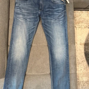 Blå jeans från Replay - Snygga blå jeans från Replay i modellen Jondrill. De har en klassisk femficksdesign och en knappgylf. Jeansen har en lätt tvättad look med subtila slitningar för en trendig stil. Lappen på sista bilden är ej kvar. Skriv för bättre bilder. Kan gå ner i pris vid snabb deal 💨 