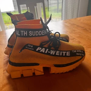 Gula sneakers med textdetaljer - Unika gula sneakers med svart textdetalj 'PAI-WEITE' och snörning. Skorna har en chunky sula och är tillverkade i ett stickat material för en modern look. Strl 43 kan hämtas i ystad eller fraktas (ej gratis frakt)