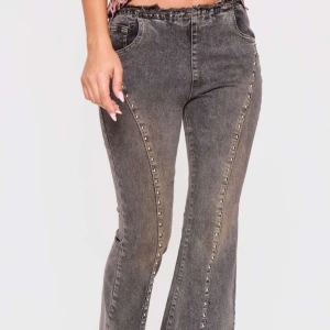 Grå jeans med nitar - Snygga grå jeans med bootcut-stil och coola nitar längs benen och bakfickorna. Perfekta för att ge din outfit en edgy touch. De har en bekväm passform och är tillverkade i jeansmaterial.