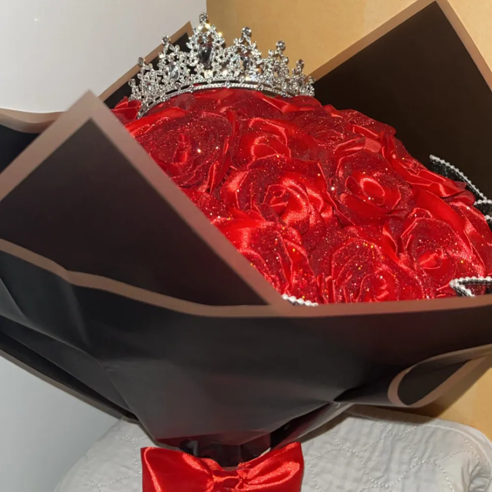 Elegant tiara dekorerad med glittriga röda rosor. Perfekt för speciella tillfällen där du vill känna dig som en drottning. Tiaran har en vacker design med pärldetaljer.. Muu.