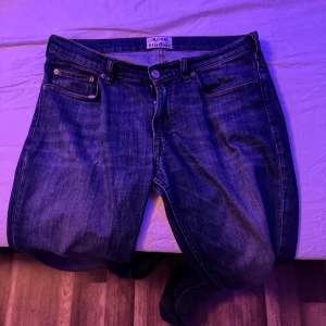 Blå jeans från Acne Studios - Snygga blå jeans från Acne Studios. Perfekta för en stilren look. Märkeslappen syns tydligt på insidan. Säljes pågrund av att de inte används. Bra skick