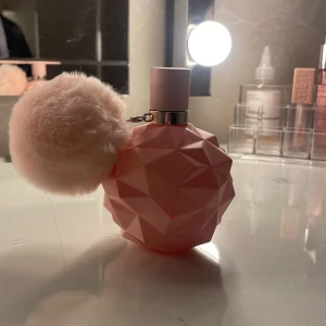 Rosa parfymflaska med fluffig boll - Säljer en unik rosa parfymflaska med en geometrisk design och en fluffig boll som dekoration. Flaskan har en modern och stilren look, perfekt för att pryda ditt sminkbord. En fin detalj för den som älskar rosa och vill ha något extra i sin parfymkollektion.