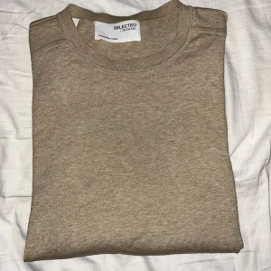 Beige tröja från Selected Homme - Säljer en stilren beige tröja från Selected Homme. Tröjan har en klassisk design med rund hals och långa ärmar, perfekt för en avslappnad look. Tillverkad i ett mjukt material som ger en skön känsla. Passar utmärkt till både jeans och chinos.