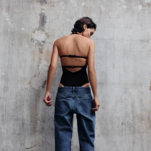 Body med halterneck - Snygg svart body med halterneck och öppen rygg med detaljer. Perfekt för en stilren look. Den är ärmlös och har en smickrande passform. Bodyn är oanvänd och har lappar kvar. I M men passar även S❣️