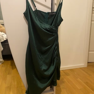 Grön satinklänning PLT - Grön klänning med slit från PLT, ganska bra skick