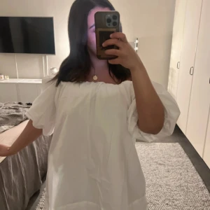 Vit klänning med puffärmar - Säljer en söt vit klänning med puffiga kortärmar och en luftig passform. Perfekt för sommarens varma dagar. Klänningen har en enkel och stilren design som gör den lätt att matcha med olika accessoarer. Perfekt till studenten!❤️