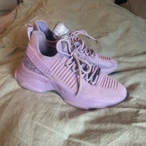 Lila sneakers från Steve Madden - Snygga lila sneakers från Steve Madden med glitter. Väldigt fint skick använda fåtal gånger, små i strl, normalt har jag 38,5-39, men fått gå upp i strl 40 i dessa sneakers. 