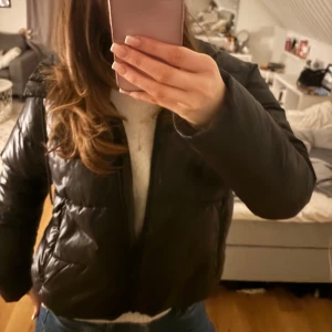 Svart dunjacka - Säljer en svart dunjacka med dragkedja. Jackan har en pufferdesign och långa ärmar, perfekt för kyligare dagar. Den är stilren och enkel att matcha med olika outfits. Tveka inte att höra av dig vid frågor!💞💞