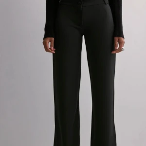 Svarta vida byxor - Snygga svarta kostymbyxor med låg midja och vida ben. Super bekvämt material. Från Nelly!