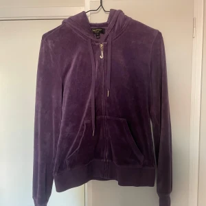 Lila hoodie från Juicy Couture - Säljer en snygg lila hoodie från Juicy Couture Black Label. Den har en snygg guld-färgad dragkedja. Tröjan är i mycket bra skick utom att några stenar på dragkedjan har ramlat av (se bild 2). Den är i storlek S. Jag säljer även en till Juicy-tröja i min profil! Priset går alltid att diskutera. Hör av er vid fler frågor/ funderingar!🥰