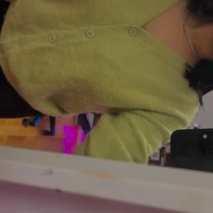 Grön kofta med knappar - Säljer en mysig grön kofta med knappar framtill. Koftan har långa ärmar och är perfekt för kyligare dagar. Den har en mjuk och fluffig textur som ger extra komfort.