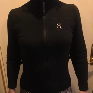 Svart fleecejacka från Haglöfs - Säljer en svart fleecejacka från Haglöfs i storlek 36 dam . Jackan har en dragkedja framtill och är långärmad. Perfekt för kyliga dagar och outdoor-äventyr. Haglöfs-logga på bröstet ger en stilren touch.