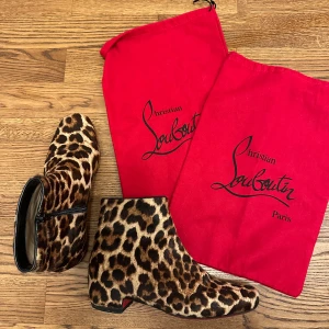 Leopardmönstrade boots från Christian Louboutin - Snygga leopardmönstrade boots från Christian Louboutin med den ikoniska röda sulan. Skorna har en dragkedja på sidan för enkel på- och avtagning. Storlek 37,5 kommer med dustbags. Helt nysulade. 