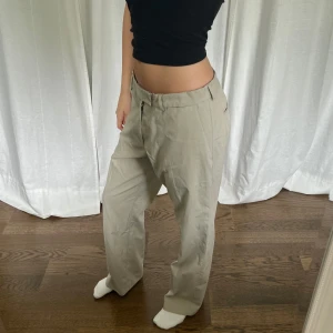Kostymbyxor - Beige lågmidjade vintage kostymbyxor från Madison Avenue. Midjemått: 90 cm. Innerbenslängd: 80 cm. Jag är 176 cm. Står ingen storlek men har sytt i gummiband som man justerar själv så de passar flera storlekar 💞