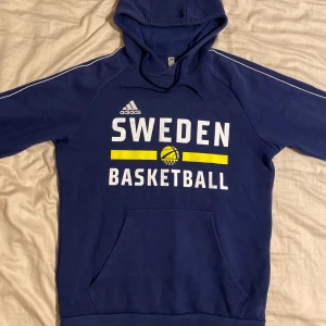 Blå basketlandslags-hoodie M - Basketlandslags-hoodie i storlek M. Fint skick, sparsamt använd. Tveka inte att höra av dig om du har frågor eller vill ha fler bilder!