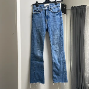 Blå jeans från Zara - Säljer ett par snygga blå jeans från Zara. De har en straight passform och är högmidjade för en bekväm och stilren look. Jeansen har en rå kant nertill som ger en cool och avslappnad vibe. Perfekta för både vardag och fest!