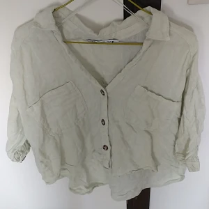 Beige linneskjorta från Zara - Säljer en superfin beige skjorta från Zara i storlek S. Den är gjord av linne vilket gör den perfekt för varma dagar. Skjortan har en avslappnad passform med knappar framtill och två bröstfickor. Den har en lite skrynklig look som ger en chill vibe. Perfekt för både vardag och fest!