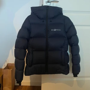 Sail Racing vinterjacka - Mörkblå puffer jacket från Sail Racing  Exklusiv vinterjacka Nytt skick, fluffig Inga skador eller slitage  Storlek M   Säljer ca 10% billigare än ordinariepris Köpt för 4200 kr
