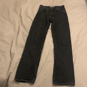 Svarta jeans från Zara - Säljer ett par svarta jeans från Zara i storlek EUR 34. De är midwaist och har en straight passform, vilket gör dem både bekväma och stilrena. Perfekta för både vardag och fest!
