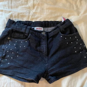 Svart shorts - Svart shorts med små stenar på. Storlek 170 men passar s och xs. Bra skick förutom att en Sten saknas, se bild.
