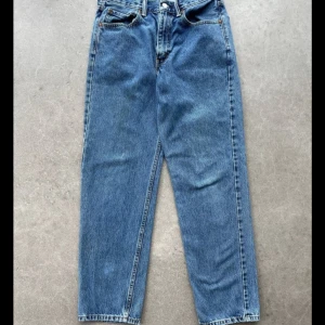 Blå jeansbyxor - Säljer ett par klassiska blå jeansbyxor. De har en rak passform och är perfekta för vardagsbruk. Byxorna har en knapp och dragkedja framtill samt fickor både fram och bak.