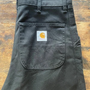 Carhartt  - Carhartt simple pant Storlek 33x34  Byxorna är i bra skick men har en gräsfläck på ena knät. Går att tvätta bort  Hör av dig vid frågor!