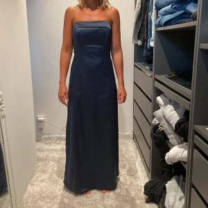 Mörkblå långklänning från Vila - Säljer en elegant mörkblå långklänning från Vila i storlek XS. Klänningen är axelbandslös och har en tight passform som framhäver figuren. Perfekt för fest eller bal! 💙