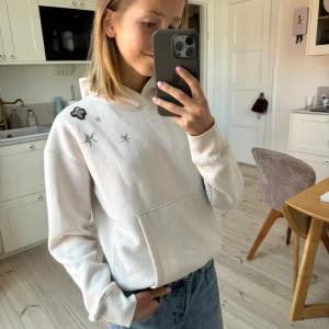 Vit hoodie med stjärnor från Hunkydory - Unik och cool hoodie i stockholmsstil. Från Hunkydory. Stjärndetaljer