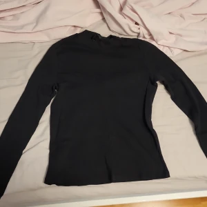 Svart långärmad tröja - Säljer en enkel och stilren svart långärmad tröja. Perfekt för både vardag och fest. Tröjan har en normal passform och är gjord i ett mjukt material som känns skönt mot huden😇 storlek M men passar på mig som har S/XS