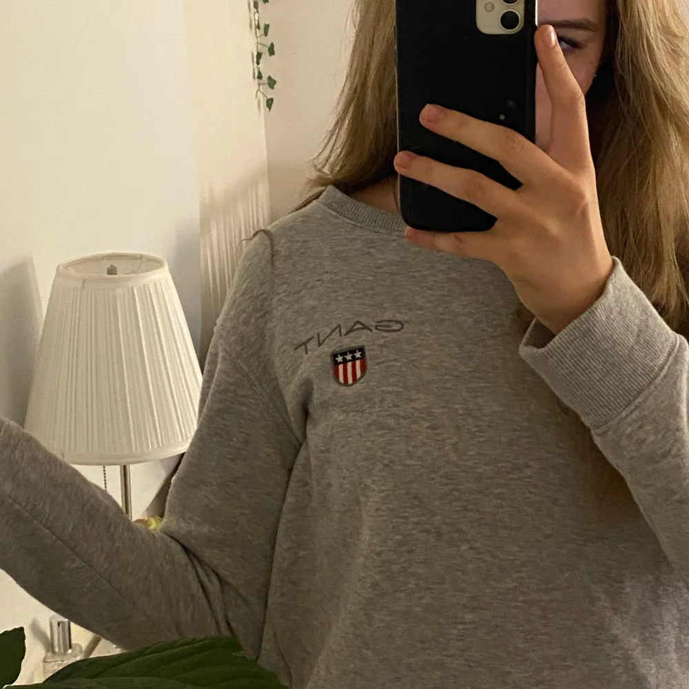 Säljer en stilren och bekväm grå sweatshirt från GANT. Den har ett broderat märke på bröstet och är perfekt för både vardag och chill. Tröjan är i bra skick och passar perfekt för höst och vinter. Den är gjord i mjukt material och har ribbade muddar vid ärmslut och nederkant.. Tröjor & Koftor.