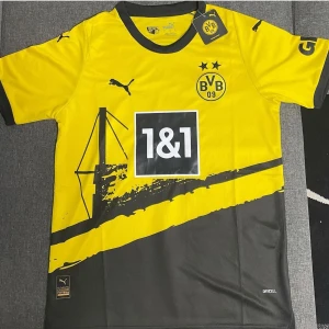 Gul och svart Borussia Dortmund fotbollströja - Säljer en snygg gul och svart Borussia Dortmund fotbollströja från Puma. Tröjan har korta ärmar och ett coolt grafiskt mönster med klubbens logga och sponsortryck på framsidan. Perfekt för alla BVB-fans! 🖤💛