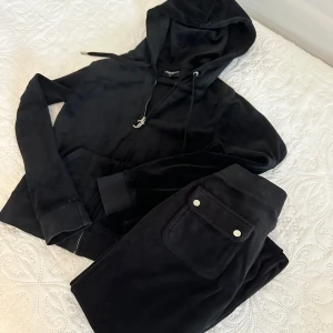 Juicy Couture svart mjukis sett  - Byxan är använd men koftan är i god skick, storlek xs på koftan och xxs på byxan. Säljs för 800kr. Saknar en metall sak på ett av snöret på byxan ( har ringat in va ja menar på sista bilden) 