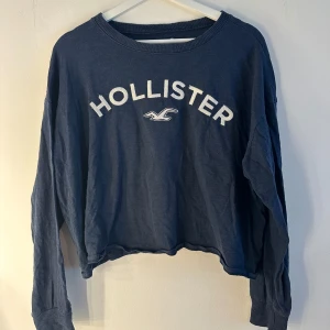 Hollister tröja  - Blå Hollister tröja i storlek M. Fint skick. Lite sliten i det broderade trycker (se andra bilden) annars är den hel och ren! Lite kortare i modellen