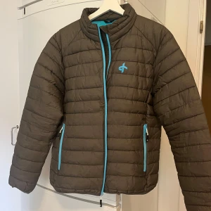 Jacka - Vadderad jacka för höst / vår   Mörkgrön med turkosa detaljer  Fint skick. Lite använd 