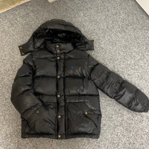 Svart dunjacka från Polo Ralph Lauren - Säljer en svart dunjacka från Polo Ralph Lauren. Jag säljer den för att den knte längre passar mig. Så klart är det inget trasigt på jackan och den är nästan som ny. Skriv vid minsta fundering /mvh Noel 