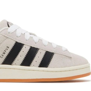Adidas Campus sneakers i beige och svart - Snygga Adidas Campus sneakers i beige mocka med klassiska svarta ränder. Skorna har en vit sula med en gummifärgad undersida och vit snörning. Perfekta för en stilren och avslappnad look. Använda 3 gånger och är för stora på mig. Bilden är tagen från Google, skicka ett meddelande så kan jag visa bättre bild på hur de ser ut.