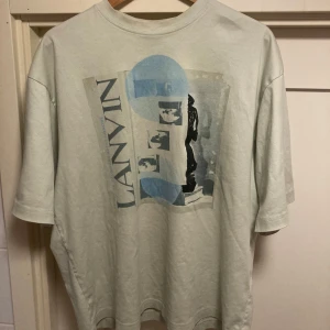 Lanvin Magiletta T-shirt  - Detta är en skitsnygg T-shirt från Lanvin. Den är i storlek S och är vit med ett asfett tryck. 10/10 skick. Nypris ligger på runt 5000-6000 kr. Hör av er vid minsta lilla fråga!