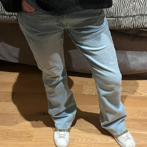 Ljusblå jeans Gina Tricot - Säljer ett par ljusblå jeans med en avslappnad passform. De har en klassisk design med fem fickor och knappgylf. Perfekta för en casual look.