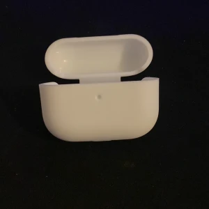 Vit hörlursfodral - Säljer ett stilrent vitt fodral för trådlösa hörlurar. Perfekt för att skydda dina hörlurar och hålla dem säkra. Fodralet har en smidig öppning och stängning.