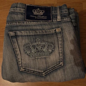 Lågmidjade jeans från Victoria Beckham - Snygga lågmidjade bootcut jeans från Victoria Beckham med broderade kronor på bakfickorna. Säljer då dom inte passar mig. Lite slit men annars bra🤗💗pris går att diskutera vid snabb affär!🥰