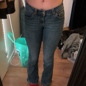 Gina tricot bootcut jeans - Snygga blå jeans från Gina tricot med en klassisk femficksdesign. De har en knapp och dragkedja framtill och är i en bekväm passform. Perfekta för en avslappnad stil. Innerbenslängd ca 83cm efter att jag sprättat upp dom. Väl använda. Nypris 500kr