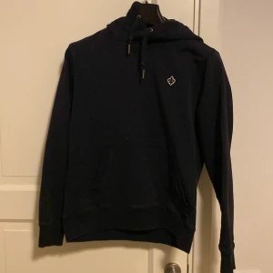 Svart hoodie från Morris - Säljer en stilren svart hoodie från Morris med en liten broderad logga på bröstet