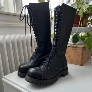 Kängor med stålhätta, combat boots från Shellys - Original Shellys kängor med stålhätta! Nästan helt oanvända. Ingen aning när dom är ifrån men skulle gissa runt 90-2000 talet. OBS! Katt finns i hemmet. Kan mötas upp i Falun.
