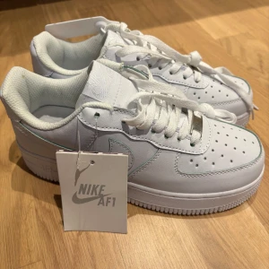 Vita Sneakers  - Säljer ett par klassiska vita Sneakers. Skorna har en stilren design med perforerade detaljer på tån och en robust sula. De är utrustade med snörning och är aldrig använda! Råka beställa i fel storlek så det är därför jag säljer dem!💓37-38 i storlek!