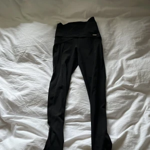 Svarta leggings från aimn - Säljer ett par svarta leggings från aimn i storlek S. De är tillverkade av 77% nylon och 23% lycra, vilket ger en skön och stretchig passform. Perfekta för träning eller en avslappnad dag. Högmidjade med en stilren design. Det är pilates byxor och därför har de en rämm runt foten. 