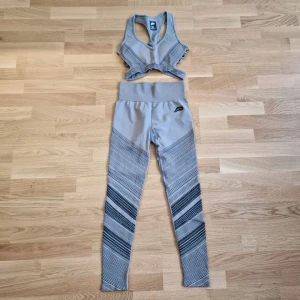 Grå träningsset med sport-bh och leggings - Träningsset från Pursue fitness. Setet består av en sport-bh i storlek M och matchande leggings i storlek S. Använt något enstaka gång.