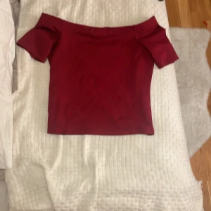Vinröd offshoulder topp - Snygg vinröd offshoulder topp med korta ärmar. Perfekt för en stilren look. Passar bra till både jeans och kjol. ❤️