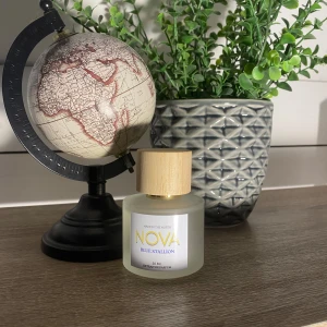 Nova Blue Stallion Parfym - Elegant parfymflaska från Novascent med doften Blue Stallion. Flaskan är frostad med en stilren träkork och rymmer 50 ml och nästan helt full. Perfekt för den som söker en sofistikerad och fräsch doft. Den kommer med kartongen man köper den i.