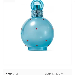 Blå parfymflaska med röda detaljer - Säljer en unik blå parfymflaska med runda röda detaljer och ett glittrande band runt halsen. Flaskan har en rund form och en matchande blå kork. Perfekt för den som vill ha en iögonfallande parfymflaska i sin samling.