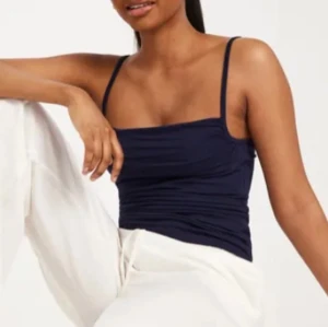 Mörkblå linnetopp - Snygg mörkblå linnetopp med smala axelband. Perfekt för varma dagar och kan enkelt matchas med olika outfits.